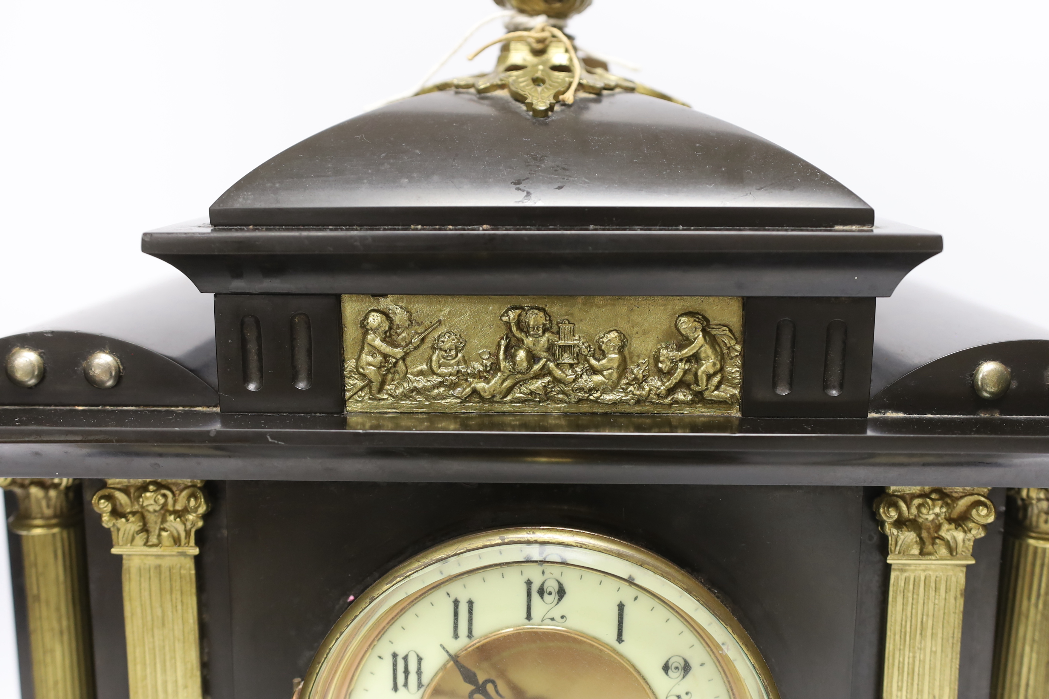 A black slate mantel clock with gilded pillars, striking on a coiled gong, 41cm high